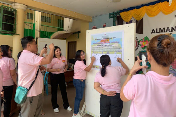 LMC-GM team cleaning school grounds during Brigada Eskwela