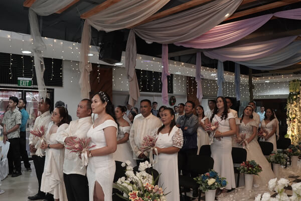 Couples exchanging vows during the mass wedding ceremony
